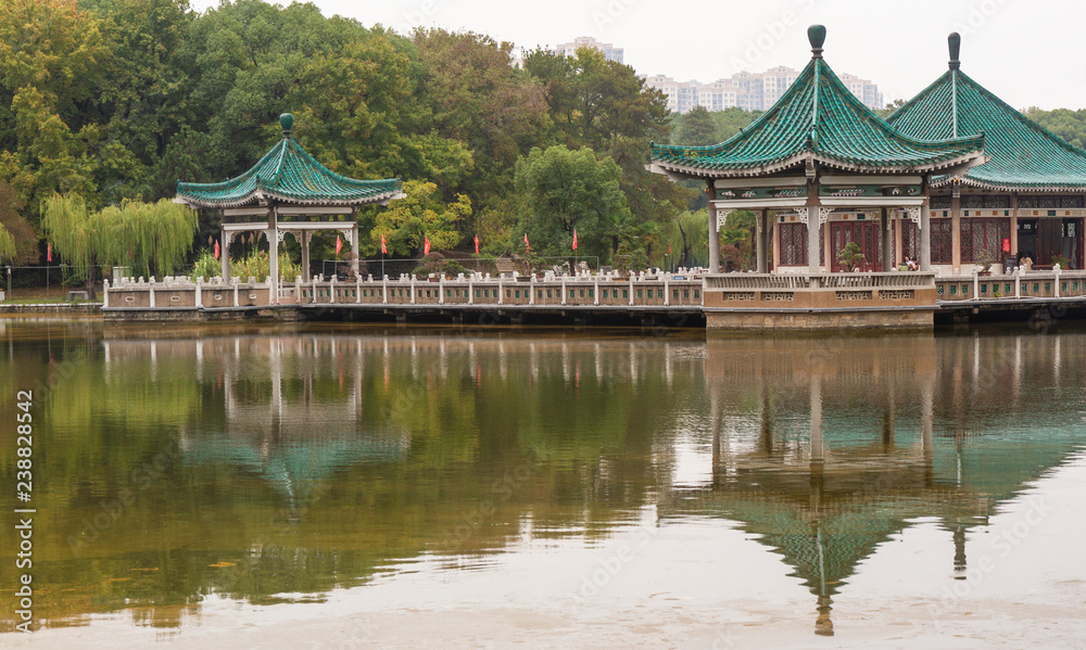 Green roofed pavilions reflected in the water at East Lake, Wuhan, China.