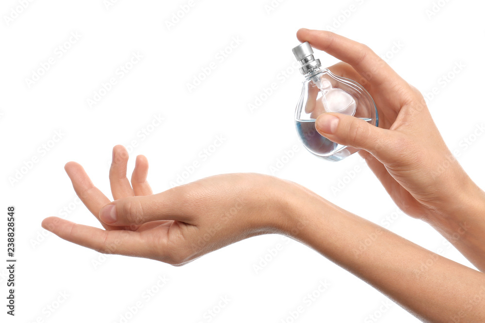 Fototapeta premium Young woman spraying perfume onto skin against white background, closeup