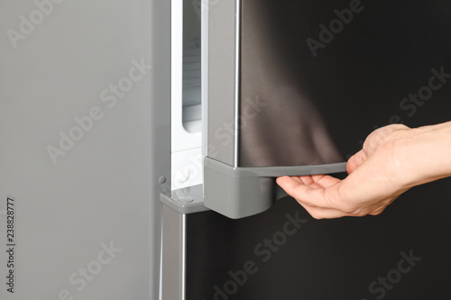 Woman opening refrigerator door, closeup. Space for text