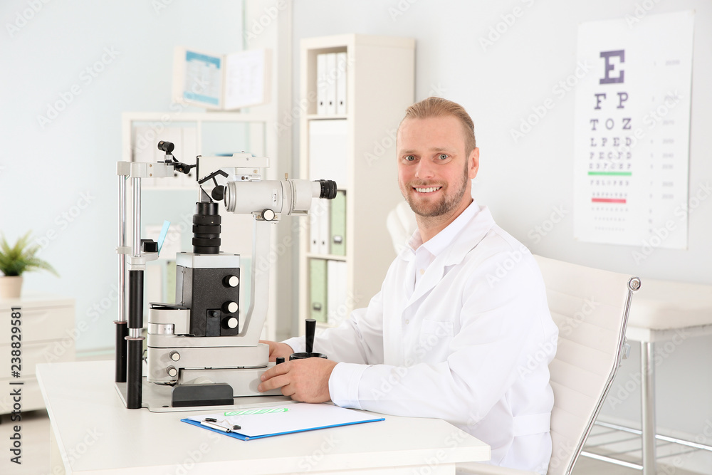 Male children's doctor with ophthalmic equipment in office Male children's doctor with ophthalmic equipment in office