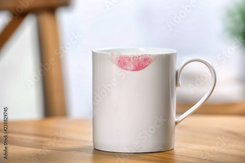 Ceramic cup with lipstick mark on table indoors
