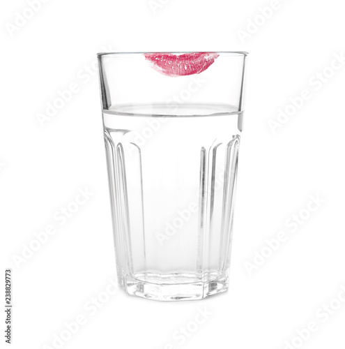 Glass of water with lipstick mark on white background