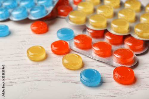 Color cough drops on wooden background photo