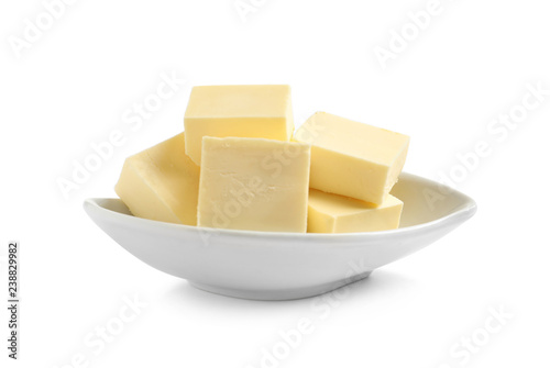 Ceramic dish with cut butter on white background