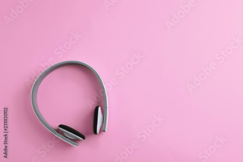 Wireless headphones on color background, top view. Space for text