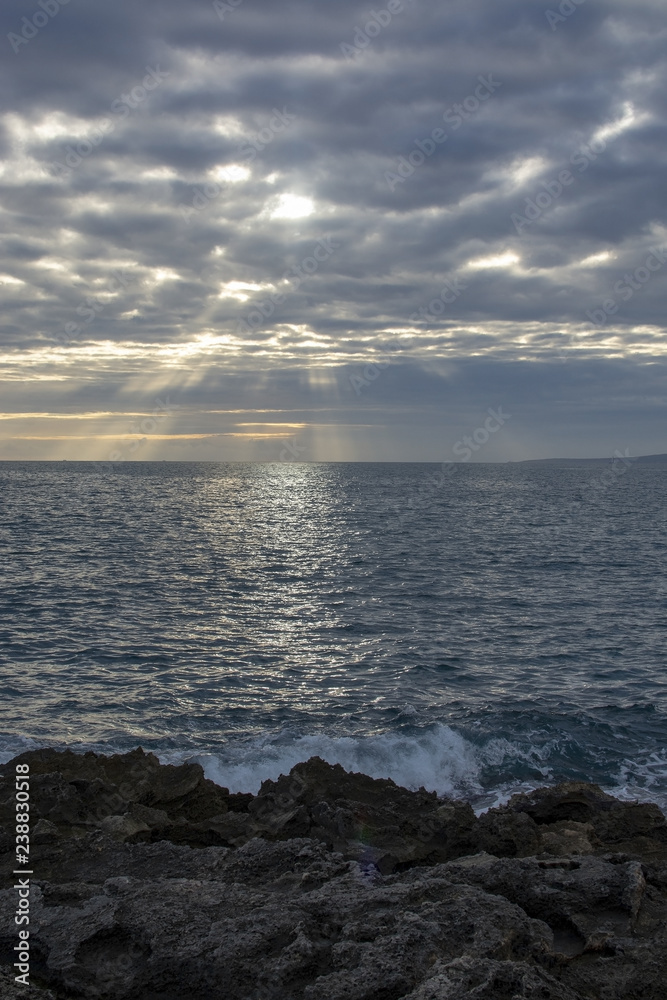 Atmospheric cloudscape with sunrays at sunset