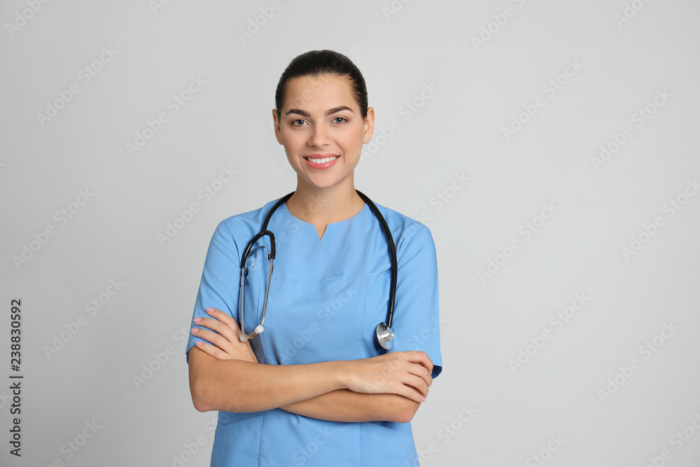 Portrait of young medical assistant with stethoscope on color background Portrait of young medical assistant with stethoscope on color background