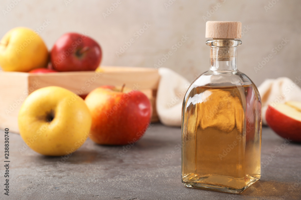 Composition with bottle of apple vinegar on table. Space for text Composition with bottle of apple vinegar on table. Space for text