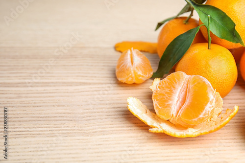Fresh ripe tangerines with green leaves on table. Space for text