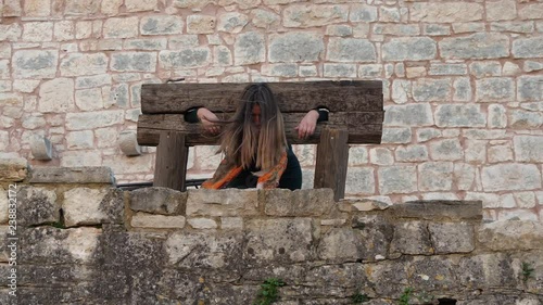 Slow motion close up footage of woman laying on old wooden empty Punishment board, pillory