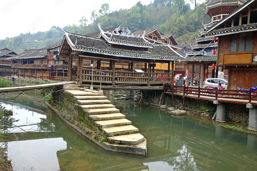 Wooden bridge of Zhaoxing Dong Zai ancient town in the morning mist, Guizhou province China. Selective and soft focus.