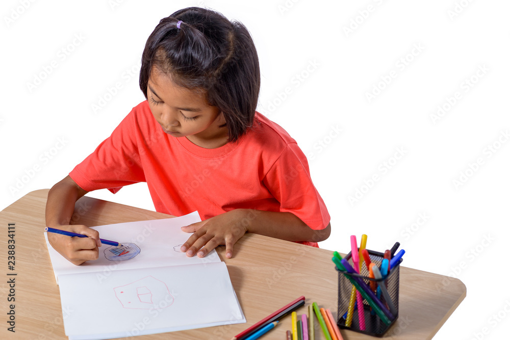 Cute cheerful child drawing using color pencil while sitting at table isolated on white background Cute cheerful child drawing using color pencil while sitting at table isolated on white background
