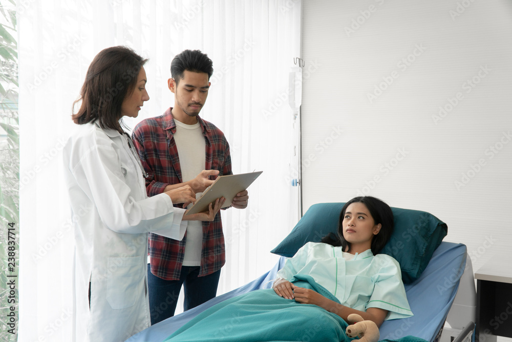 Patients women stay at hospital and talk with Doctor In patient room. Medicine, age, health care and people concept - Health visitor and a Asian woman and Asian man during visit at hospital ward. Patients women stay at hospital and talk with Doctor In patient room. Medicine, age, health care and people concept - Health visitor and a Asian woman and Asian man during visit at hospital ward.