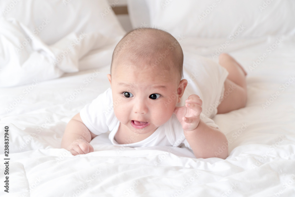 Beautiful smiling baby crawling for the first time. Adorable baby boy in white sunny bedroom. Newborn child relaxing on bed. Nursery for young children concept. - Image Beautiful smiling baby crawling for the first time. Adorable baby boy in white sunny bedroom. Newborn child relaxing on bed. Nursery for young children concept. - Image