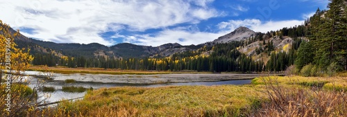 Silver Lake by Solitude and Brighton Ski resort in Big Cottonwood Canyon. Panoramic Views from the hiking and boardwalk trails of the surrounding mountains, aspen and pine trees in brilliant fall autu