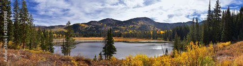 Fototapeta Naklejka Na Ścianę i Meble -  Silver Lake by Solitude and Brighton Ski resort in Big Cottonwood Canyon. Panoramic Views from the hiking and boardwalk trails of the surrounding mountains, aspen and pine trees in brilliant fall autu