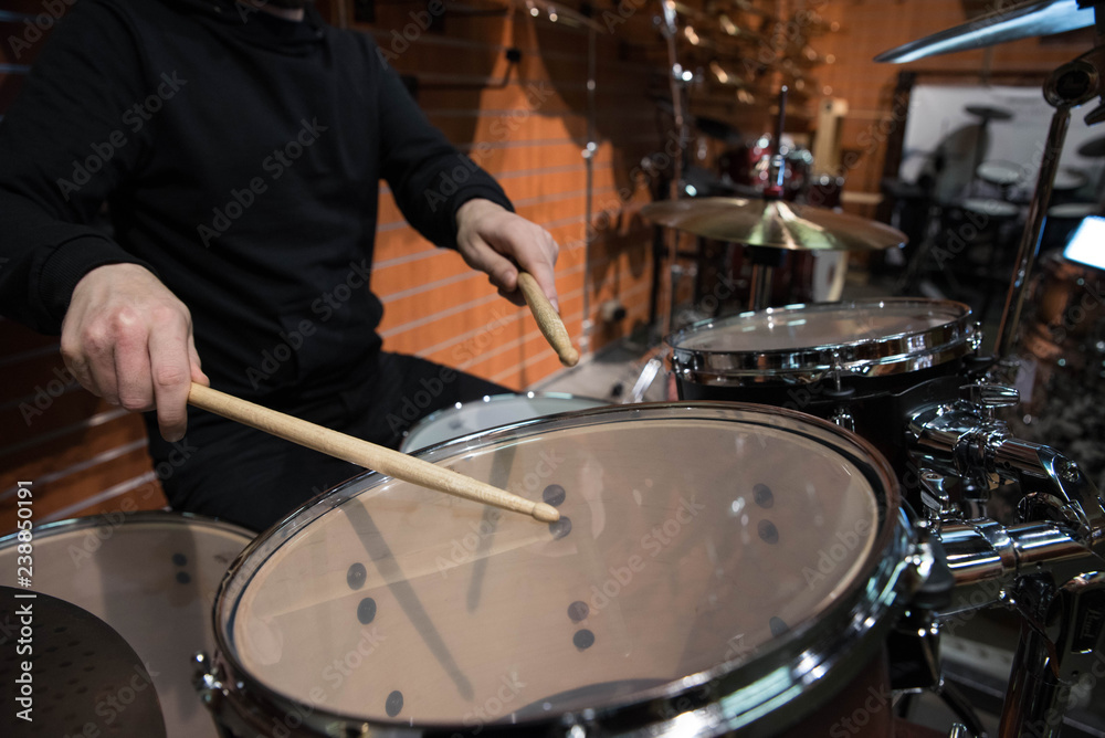 Professional drum set closeup. Man drummer with drumsticks playing drums and cymbals, on the live music rock concert or in recording studio   