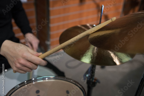 Professional drum set closeup. Man drummer with drumsticks playing drums and cymbals, on the live music rock concert or in recording studio 