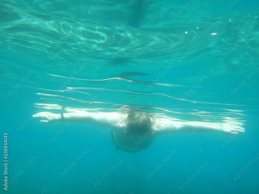 Naklejka premium Man swimming under water into the sea