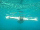 Man swimming under water into the sea