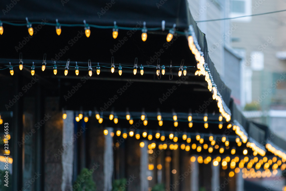 Rows of Christmas lights hanging from tents in front of shops in downtown Portland, Oregon.