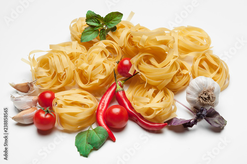 Pasta Spaghetti with ingredients for cooking pasta on a white background, top view.