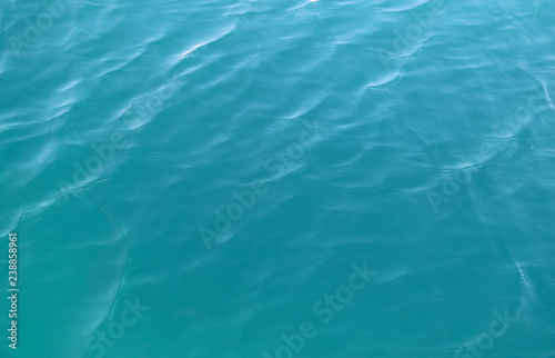 Closeup of clear blue sea water surface under sunlight. Natural art background and template. 