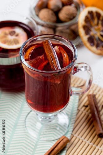 Mulled wine in glass with orange and spices .