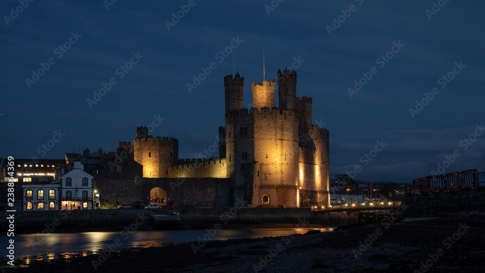 Caernarfon Castle, often anglicized as Carnarvon Castle, is a medieval fortress in Caernarfon, Gwynedd, north-west Wales. Taken here lit up at night