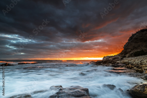Beautiful clouds at sunset on the rocky seashore