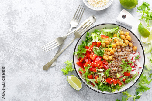 Healthy and delicious bowl with buckwheat and salad of chickpea, fresh pepper and lettuce leaves. Dietary balanced plant-based food. Vegan and vegetarian dish. Top view. Flat lay