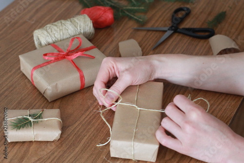 Woman packing Christmas gifts. Christmas presents concept. Wrapping, eco pack, parcel, hand, craft, handmade