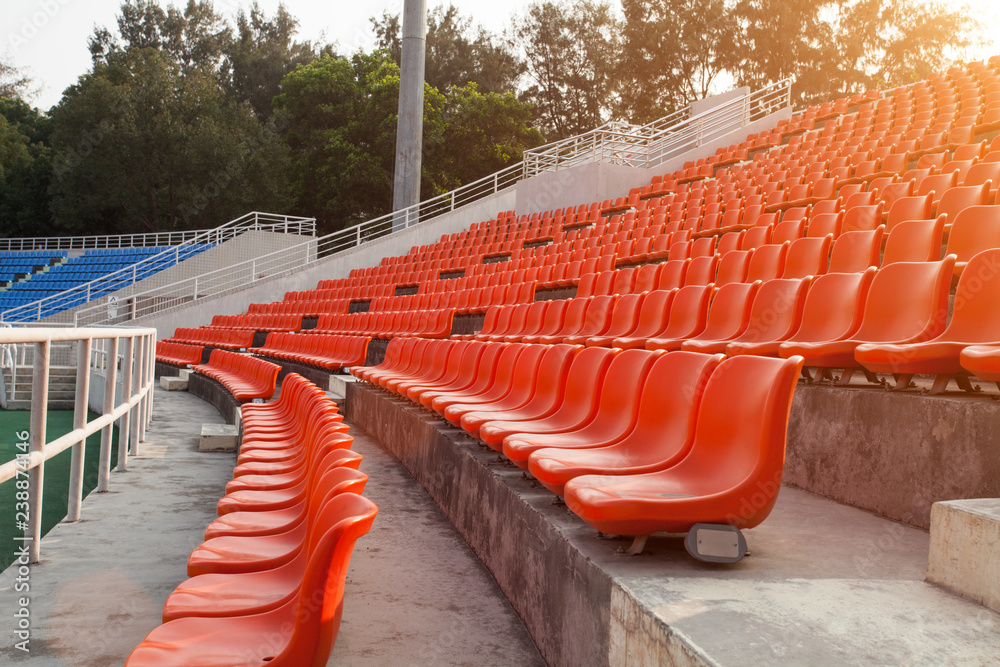 Naklejka premium Empty orange plastic seats at stadium