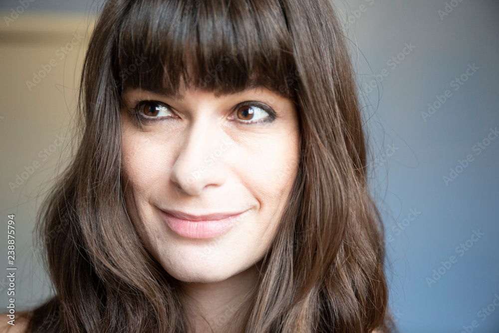 Young woman close-up portrait. Caucasian with brown long hair and bangs. Young woman close-up portrait. Caucasian with brown long hair and bangs.