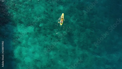 kayakers kayaking over coral reefs in archipelago Bacuit in Philippines photo
