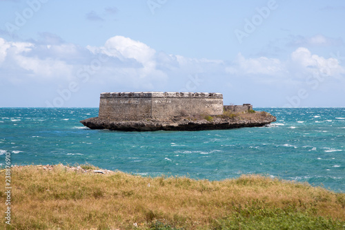 Sao Lourenco Blockhouse. San Lorenzo Island, fort nearby grassy shore and coastline of Mozambique island, Indian ocean coast. Portuguese East Africa.