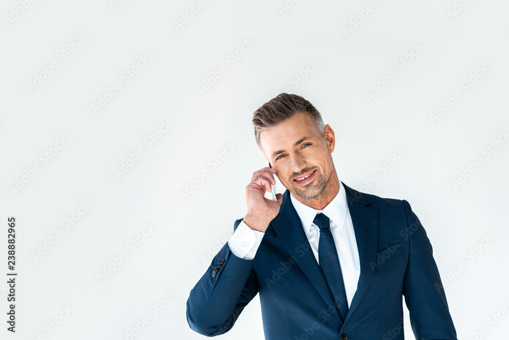 smiling handsome businessman talking by smartphone and looking at camera isolated on white smiling handsome businessman talking by smartphone and looking at camera isolated on white