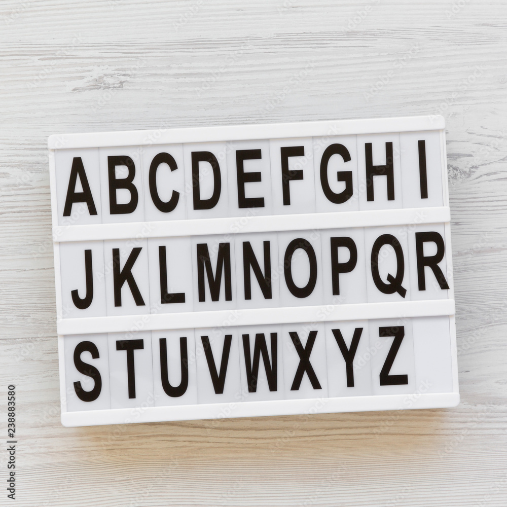 Letters from A to Z. English alphabet on modern board over white wooden surface, overhead view. Back to school concept. From above, flat lay, top view. Letters from A to Z. English alphabet on modern board over white wooden surface, overhead view. Back to school concept. From above, flat lay, top view.