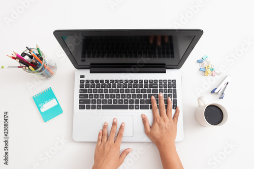 Business woman type on laptop computer on white office desk