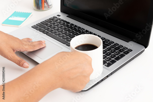 women working on a laptop and holding a cup of coffee on a white background
