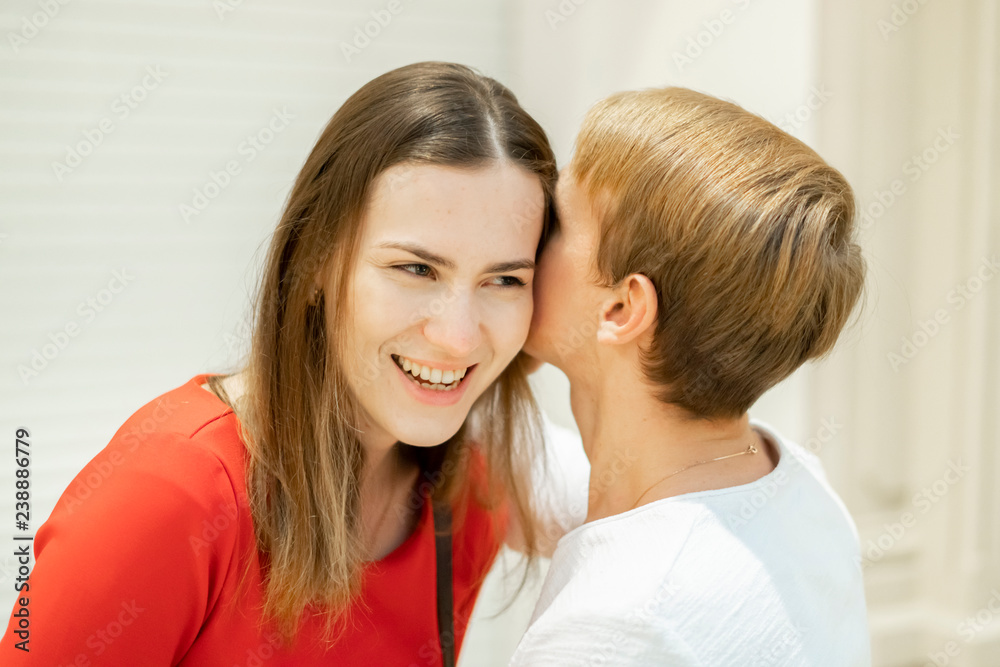 young man telling a secret to his girlfriend close to the ear, love couple f young man telling a secret to his girlfriend close to the ear, love couple f
