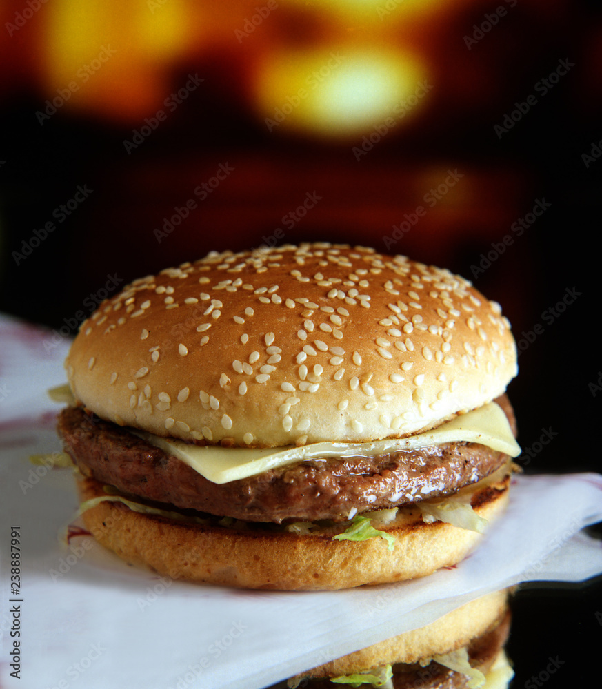 Panecillo de semillas con una hamburguesa, lechuga, tomate y queso