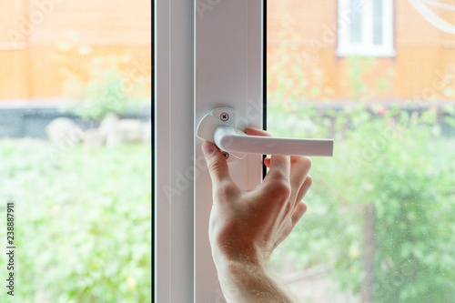 The employee opens a protective cap from the element of the plastic window. Preparing a plastic window for minor repairs.