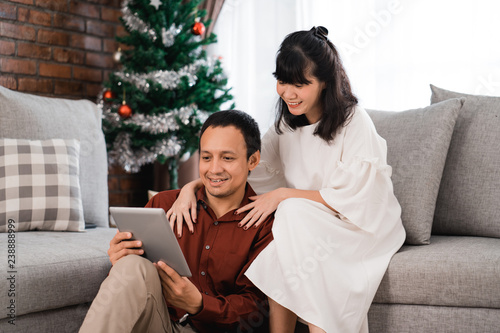 lovely couple using tablet in christmas day photo