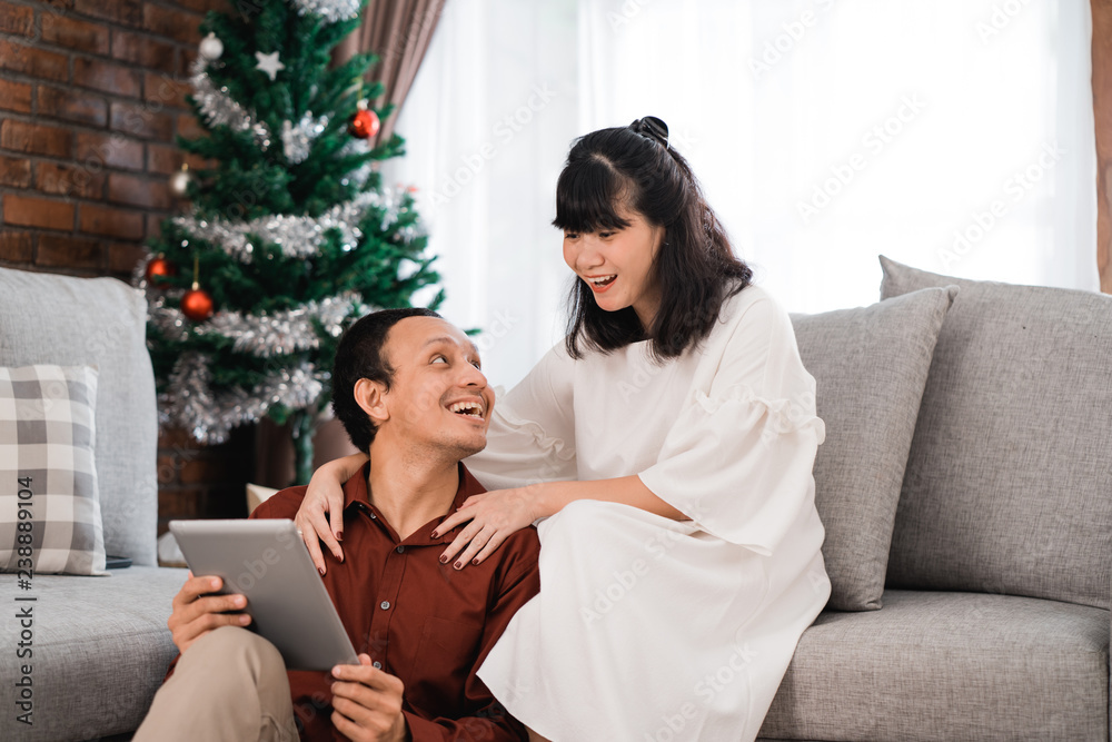 man and woman in living room together using tablet man and woman in living room together using tablet