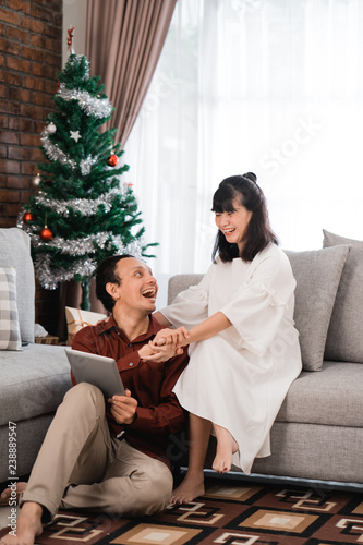 excited couple raise their arm when using tablet photo