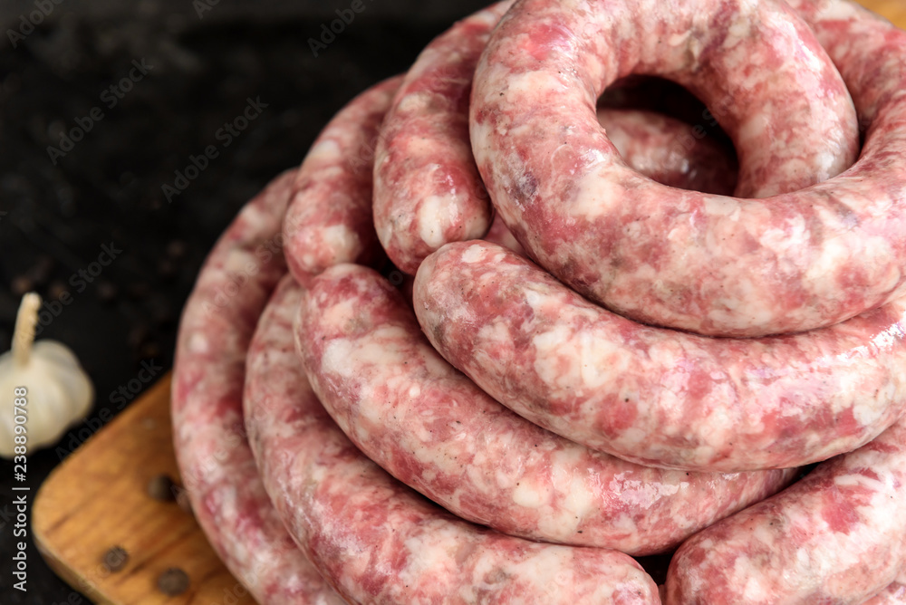 Homemade raw sausage on black background. Homemade raw sausage on black background.
