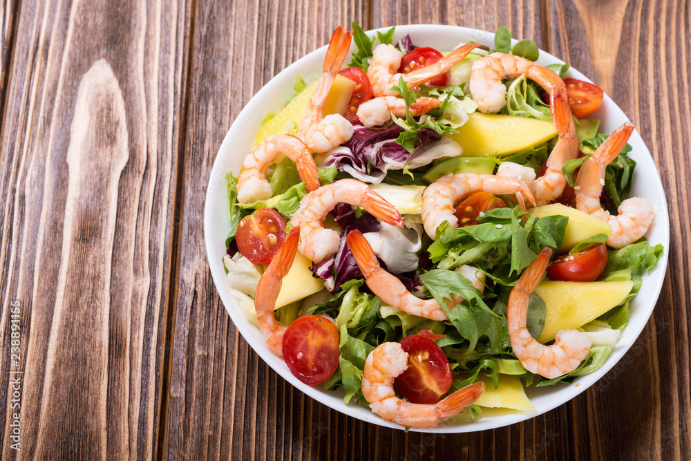 Mix of salad with shrimps , avocado and cherry tomatoes . Healthy food background Mix of salad with shrimps , avocado and cherry tomatoes . Healthy food background