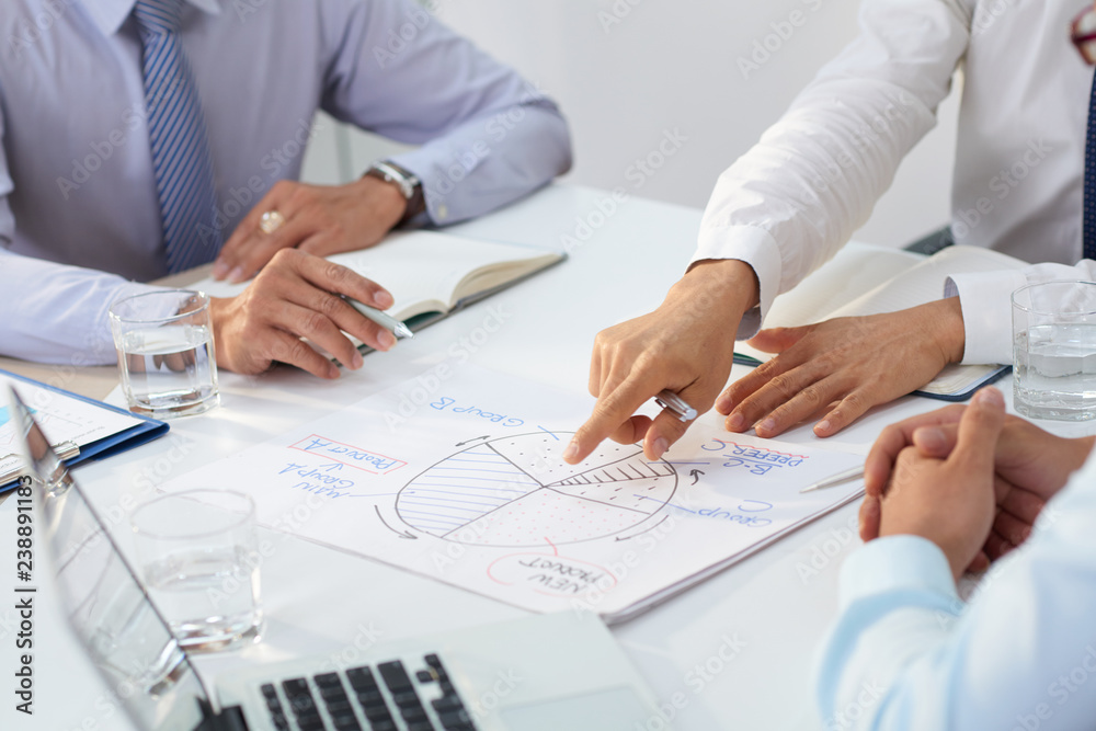 Cropped image of business team discussing diagram at meeting