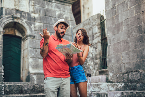 Traveling couple of tourists walking around old town. Vacation, summer, holiday, tourism: concept.